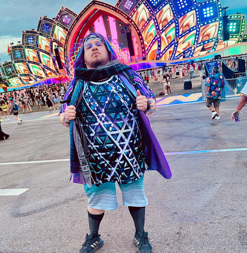 An image of a festival attendee in festival fashion at the EDC electric daisy carnival main stage, wearing a triangle laser design tank top by Roxy Tocin